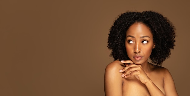 Seksowna atrakcyjna młoda Afroamerykanka pozuje topless na brązowo