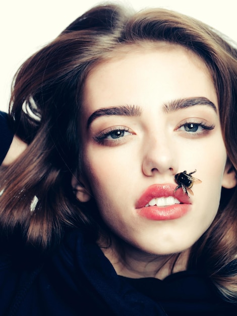 Seksowna dziewczyna z pszczołą na czerwonych ustach