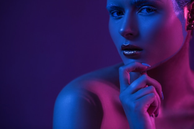 Seksowna kobieta na Purpurowym tło chwyta ręce blisko twarzy