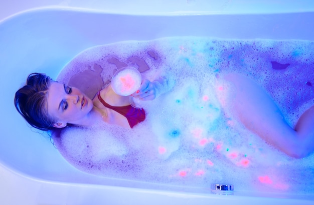 Seksowna kobieta w kąpieli neony neon spa czas kąpieli mycie ciała pianka do pielęgnacji włosów na głowie bańka szamponu