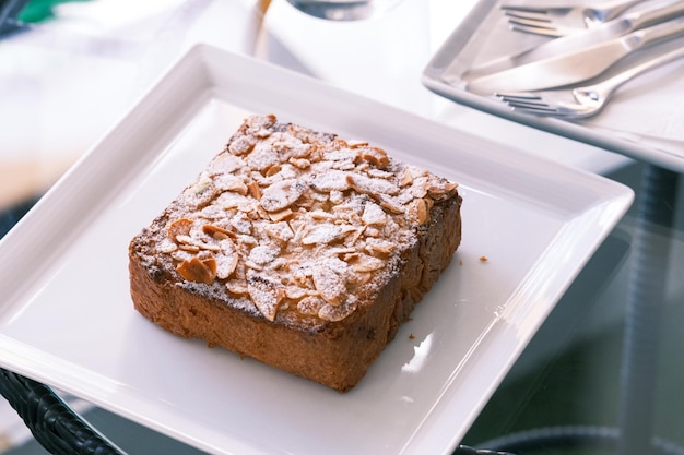 Zdjęcie selektywne skupienie bostock z dodatkiem kremu migdałowego frangipane z pieczonych plasterków brioche widok z bliska tradycyjny francuski słodki tost francuski cukiernia tost migdałowy