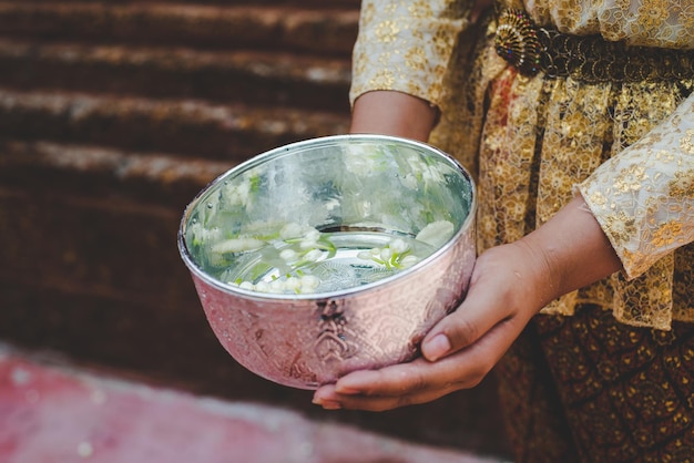 Selektywne skupienie Kobiece ręce trzymające miskę z wodą w świątyniach i zachowanie dobrej kultury Tajów podczas festiwalu Songkran Tajlandzki Nowy Rok Dzień Rodziny w kwietniu
