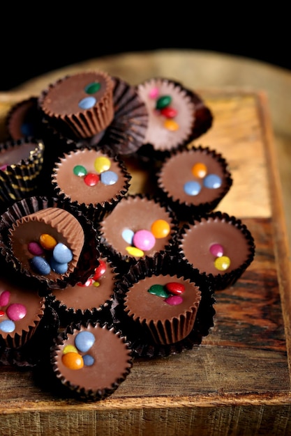 Selektywne skupienie Makro Małe czekoladowe cukierki na drewnianej desce