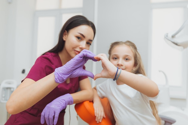 Selektywne Skupienie Rąk Dentysty I Małej Dziewczynki W Kształcie Serca