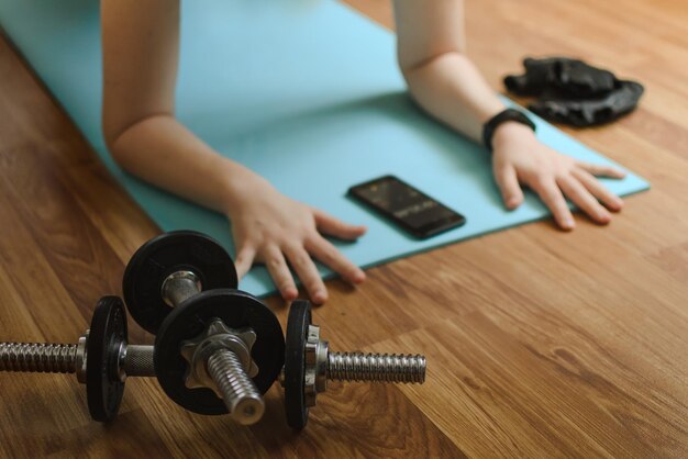 Selektywne skupienie się na hantlach sportowych w tle ręce osoby i telefon komórkowy