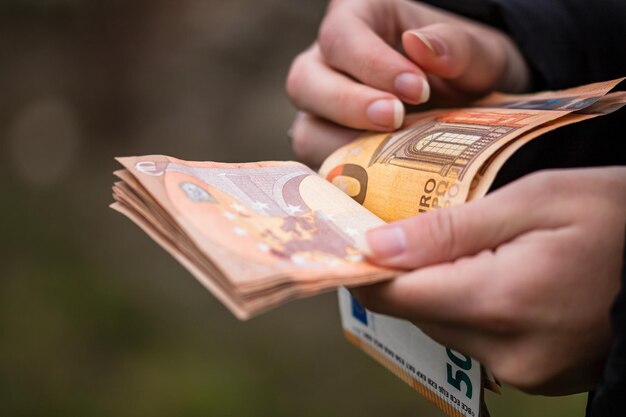 Zdjęcie selektywne skupienie się na szczegółach banknotów euro. liczenie lub dawanie banknotów euro. światowa koncepcja pieniądza, koncepcja inflacji i gospodarki