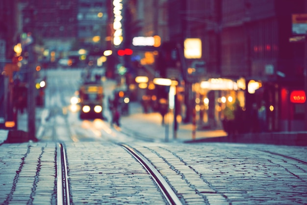 Selektywne skupienie się na torach tramwajowych z niewyraźnym miastem w tle