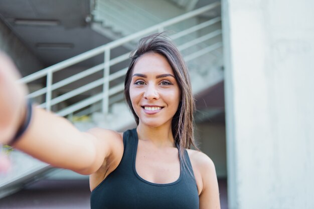 Selfie portret kobiety wesoły sport w odzieży sportowej na zewnątrz w środowisku miejskim