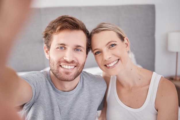 Selfie w sypialni mężczyzny i kobiety jako pary Portret młodych szczęśliwych i uśmiechniętych ludzi robiących razem zdjęcie rano i ubranych w piżamę