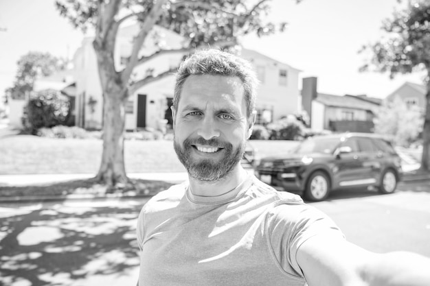 Selfie wyraża pozytywne emocje szczęśliwy mężczyzna z brodą robi selfie zdjęcie męskiej twarzy portret