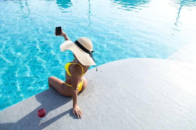 Selfie Za Pomocą Smartfona. Portret Atrakcyjna Brunetka Dziewczyna Selfie Przy Basenie.