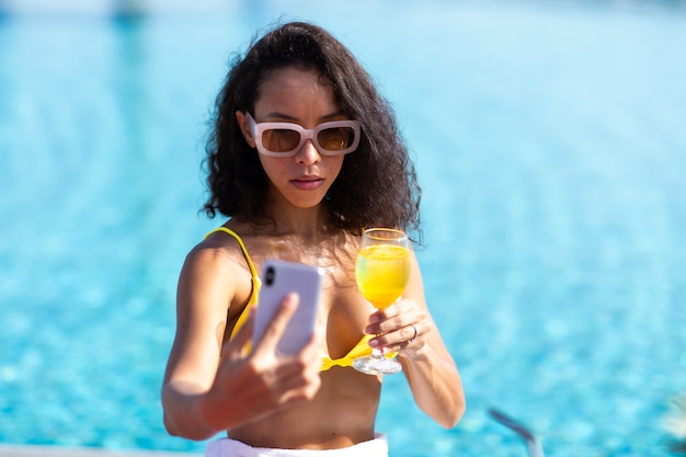 Selfie Za Pomocą Smartfona. Portret Atrakcyjna Brunetka Dziewczyna Selfie Przy Basenie.