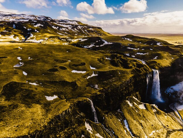 Seljalandsfoss znajduje się w regionie południowym na Islandii Zwiedzający mogą spacerować za wodospadem Seljalandsfoss ze wspaniałym zachodem słońca w popularnej miejscowości turystycznej Część złotego koła