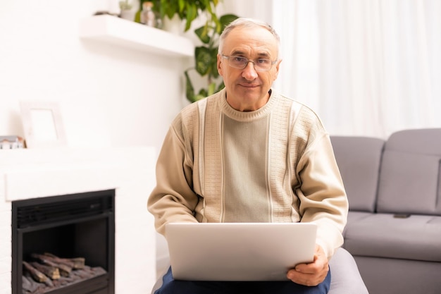 Senior pracuje na laptopie, starszy mężczyzna.