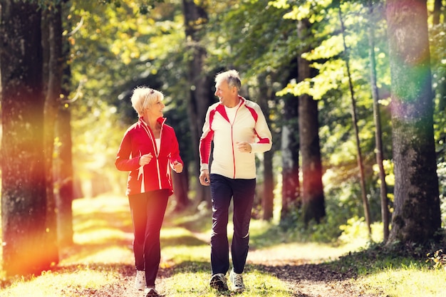 Seniorzy jogging na leśnej drodze