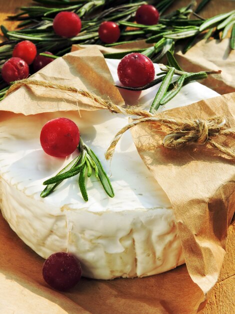 Ser Camembert w papierze, żurawinie i świeżym rozmarynie.