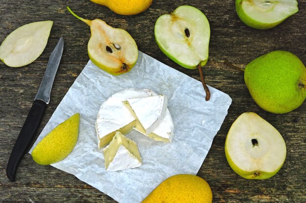 Zdjęcie ser camembert z gruszkami na drewnianej powierzchni.