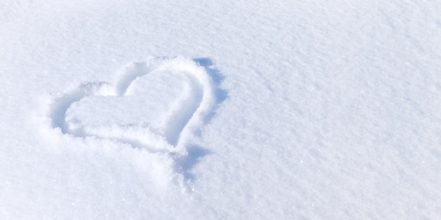 Serce jest rysowane na śniegu Banner na walentynkowy symbol świąteczny miłości na białym śniegu w zimie