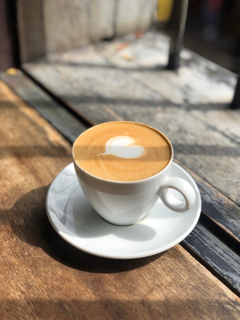 Serce latte art na filiżance kawy na stole