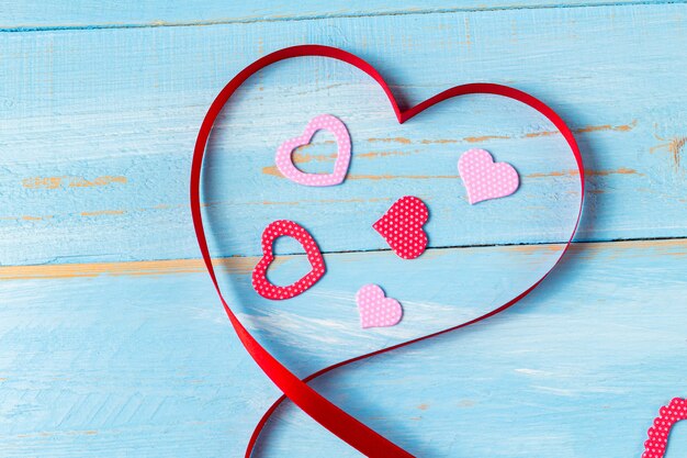 Serce w kształcie wstążki na niebieskim tle drewnianych. Prezent na Walentynki