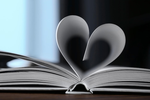 Zdjęcie serce ze stron książki na ciemnym rozmytym tle