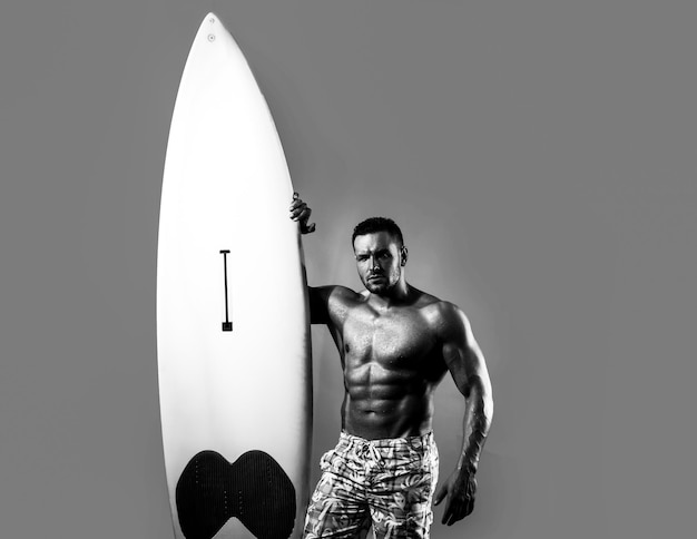 Serfer muskularny mężczyzna z neonową deską surfingową na niebieskim tle Mężczyzna surfer z dopasowanym ciałem Seksowny surfer z deską surfingową Letni sport