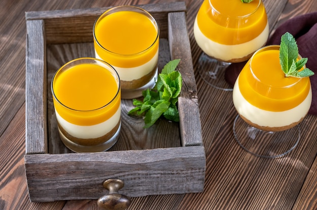 Sernik mango serwowany w szklankach na rustykalnym tle
