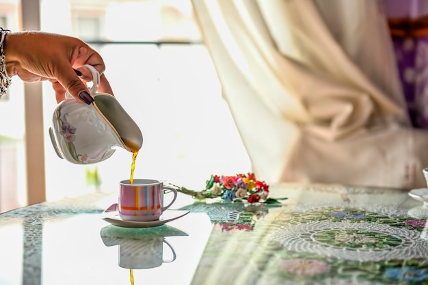 Serwowanie herbaty w szklanej filiżance na stołowym naturalnym jasnym tle
