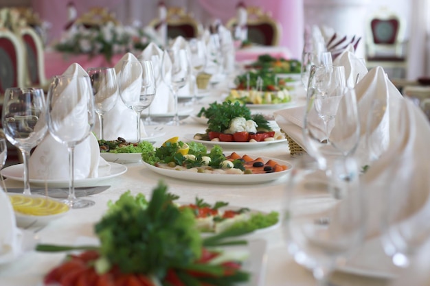 Serwowany stół podczas bankietu weselnego ozdobiony białymi serwetkami