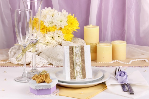 Serwujący bajeczny stół weselny w fioletowym i żółtym kolorze na białym i fioletowym tle tkaniny