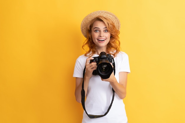 sesja zdjęciowa. praca fotograficzna. robienie zdjęć. fotografka. zdziwiona kobieta w słomkowym kapeluszu fotografowania. dziewczyna trzymać aparat fotograficzny. fotografia amatorska i profesjonalna. letnia sesja zdjęciowa.