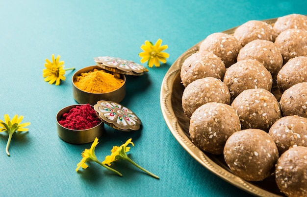 Sezam lub ril gul lub Tilgul laddu z haldi kumkum z kwiatami na festiwal Makar Sankranti, selektywne skupienie