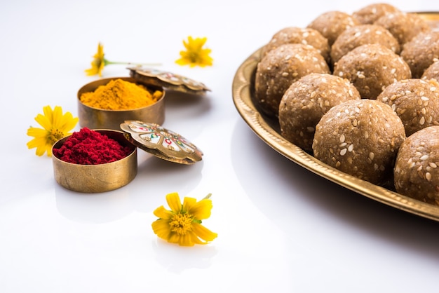 Sezam lub ril gul lub Tilgul laddu z haldi kumkum z kwiatami na festiwal Makar Sankranti, selektywne skupienie