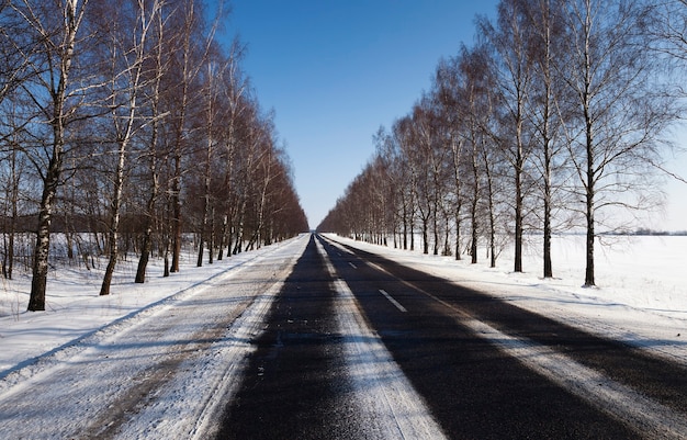 Sfotografowana droga zimą. zimą droga pokryta jest śniegiem