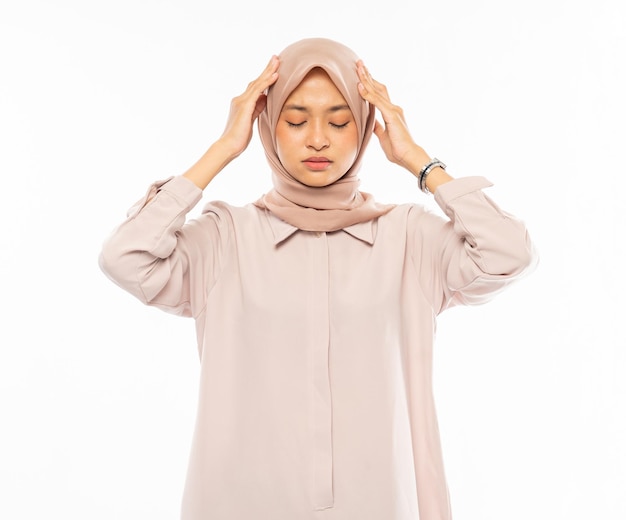 Sfrustrowana azjatycka kobieta w hidżabie trzymająca głowę z bólem głowy