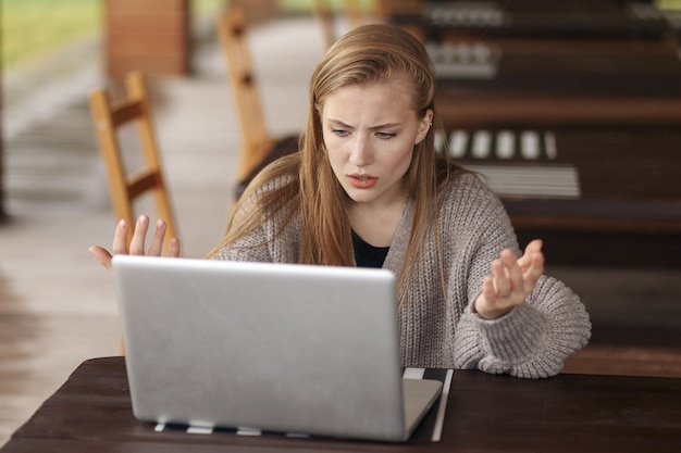 Zdjęcie sfrustrowana zmartwiona kobieta patrzy na laptopa zszokowana złymi wiadomościami.