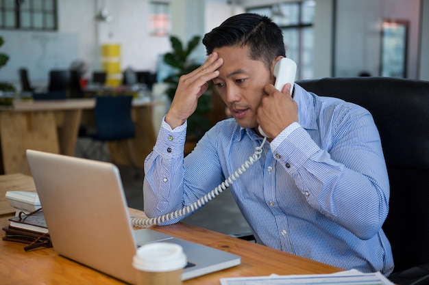 Sfrustrowany biznesmen rozmawia przez telefon