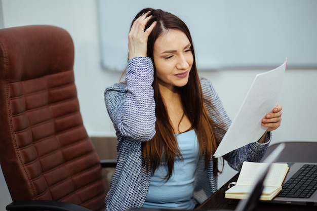 Zdjęcie sfrustrowany bizneswoman za pośrednictwem coronavirus. zestresowany zmęczony bizneswoman uczucie wyczerpania siedzi przy biurku z laptopem