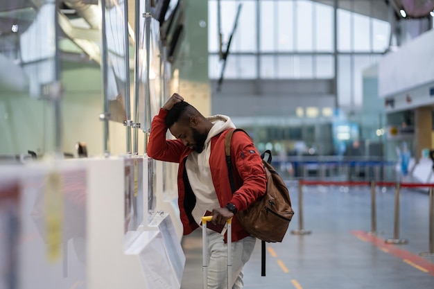 Sfrustrowany, smutny pasażer z Afryki, mający problemy z odprawą na lot