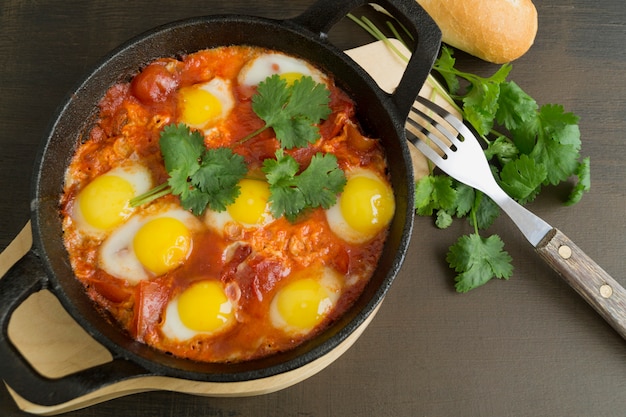 Shakshuka na patelni. Omlet z pomidorami, pieprzem, warzywami i ziołami.