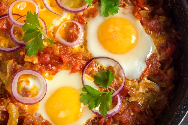 Shakshuka, tradycyjne danie izraelskie. Słoneczne jajko z duszonymi pomidorami.