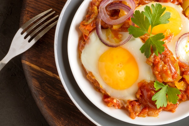 Zdjęcie shakshuka, tradycyjne danie izraelskie. słoneczne jajko z duszonymi pomidorami.