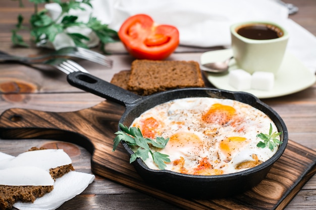 Shakshuka Ze Smażonych Jajek Z Pomidorami I Pietruszką Na Patelni, Chleb Z Masłem I Kawą