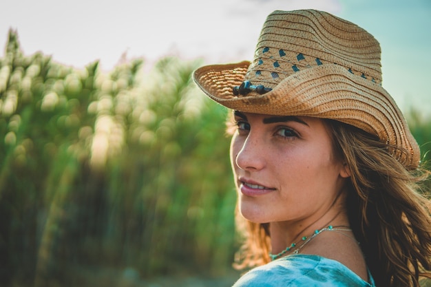 Shallow fokus strzał europejskiej kobiety w kowbojskim kapeluszu na plaży