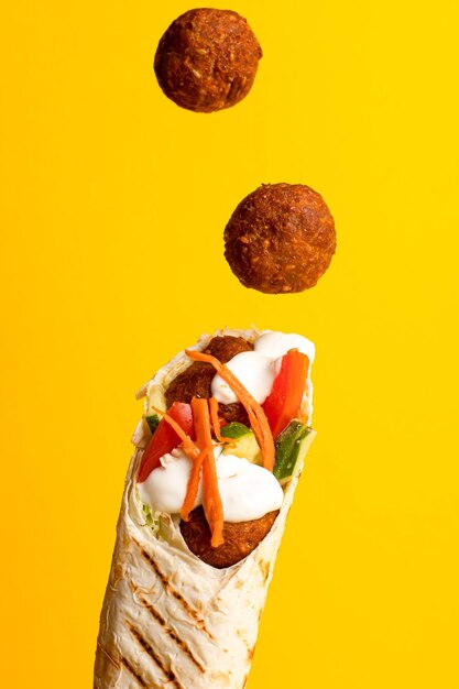 Shawarma z bocznym widokiem falafel na żółtym tle