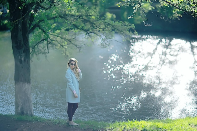 shore pond park dorosła dziewczyna / spacer w parku miejskim, piękna dziewczyna w pobliżu stawu w miejskim obszarze rekreacyjnym na świeżym powietrzu