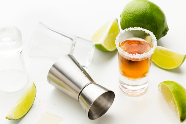 Zdjęcie shot tequila pod dużym kątem z plasterkami limonki i solą