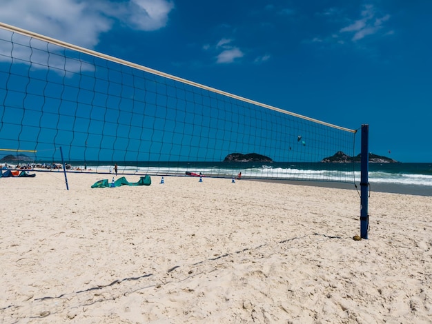 Siatka do siatkówki lub futvolei na plaży Barra da Tijuca Rio de Janeiro Brazylia Słoneczny dzień z błękitnym niebem i chmurami Windsurfing na morzu