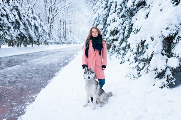 Siberian husky siedzi w pobliżu młodej kobiety