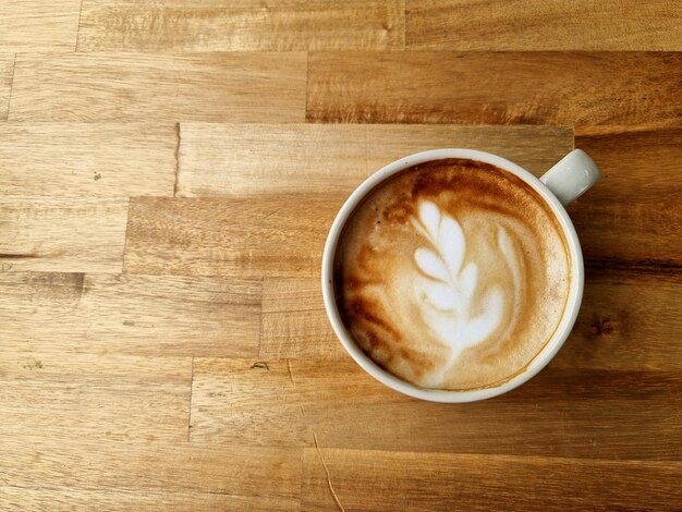 Sideway shop coffee filiżanka gorącej kawy latte art na drewnianym tle